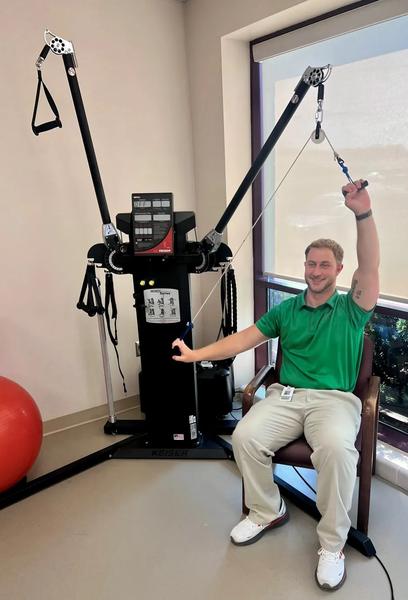 Trainer demonstrating cable machine