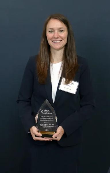 Brooke Randol, RN holding Caregiver of the Year award