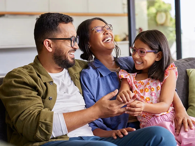 Family laughing on couch