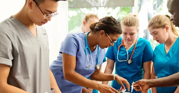 Students in blue scrubs working