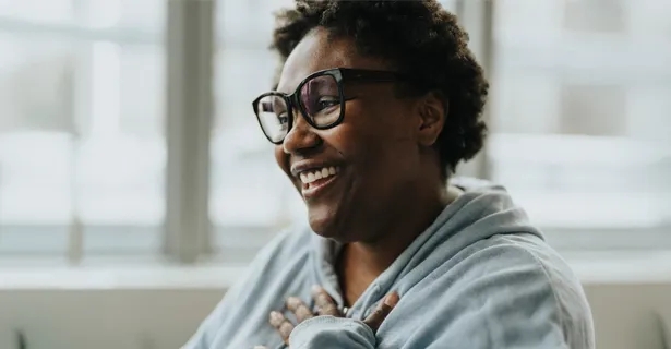 Woman smiling with her hand on her chest