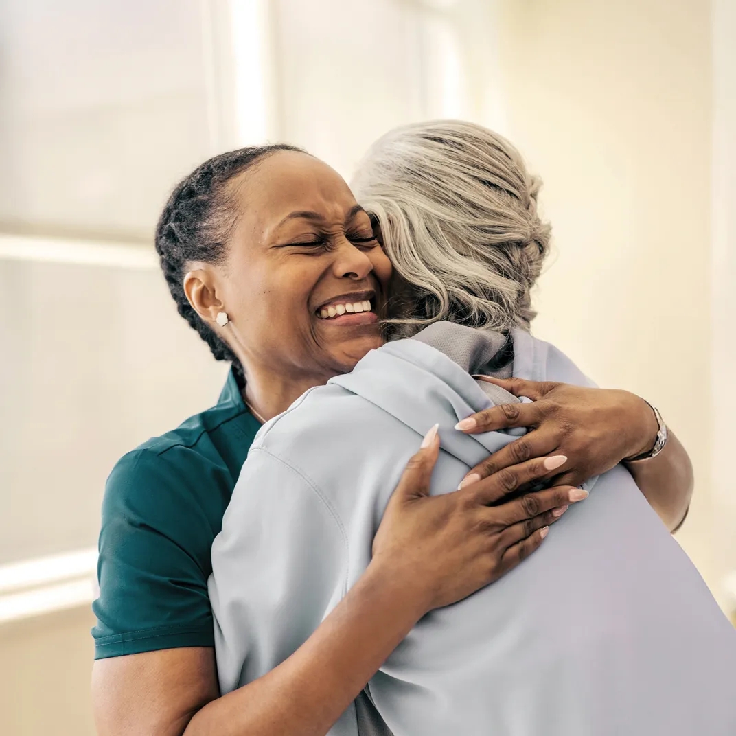 Woman nurse hugging woman patient