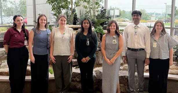 Purdue students standing in front of the PRMC waterfall